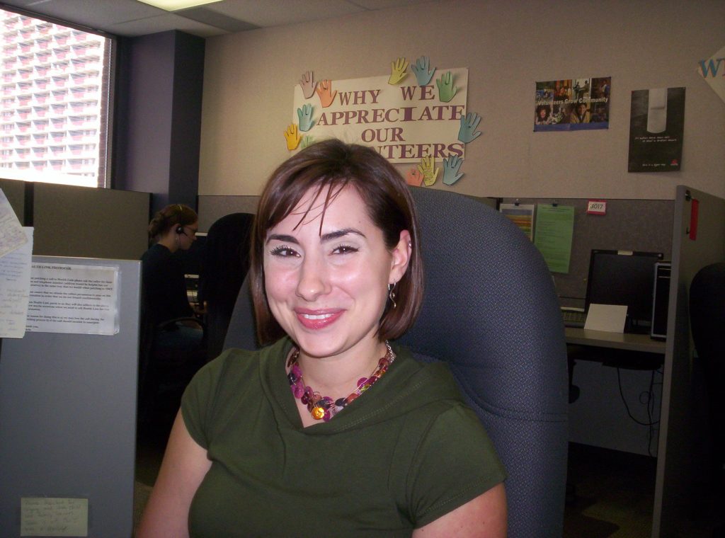 img des: Michelle Wickerson sitting in an office chair, wearing a green shirt