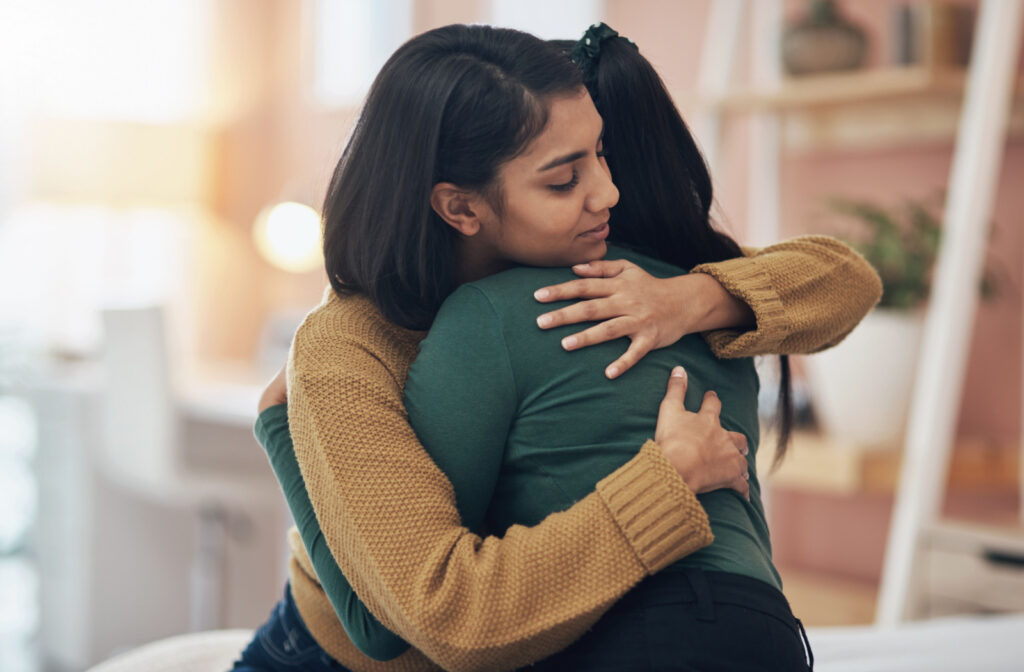 A person hugging a loved one to show signs of empathy and support for self-harm and mental health struggles.