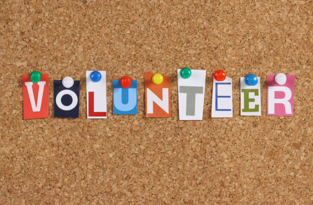 Letters pinned to a bulletin board that spell out the word volunteer.