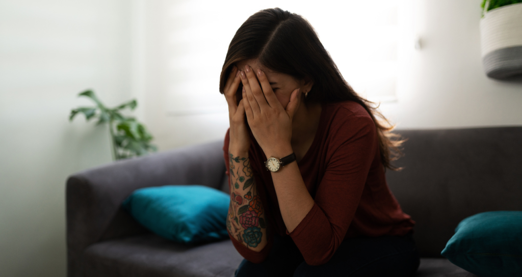 Photo of a person with their head in their hands, looking overwhelmed